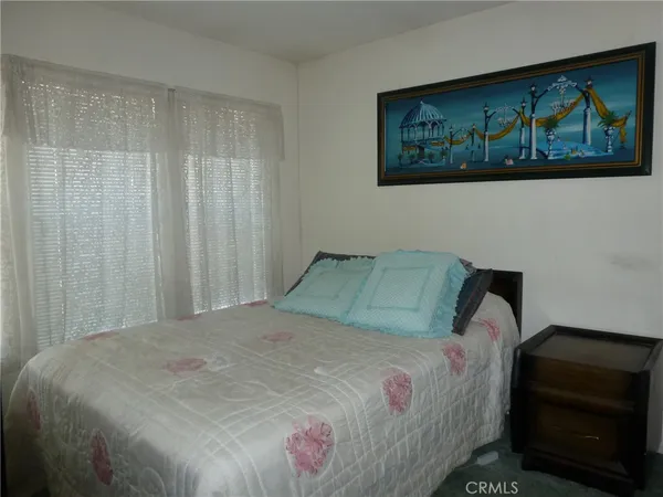 a bedroom with a bed and a painting on the wall