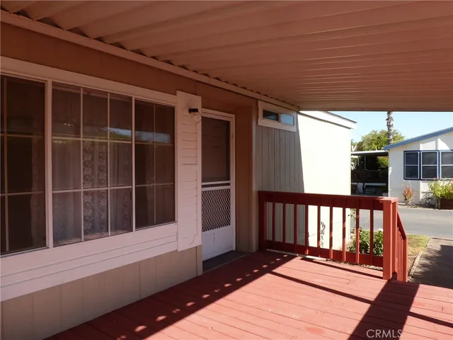 a view of balcony with wooden floor and floor to ceiling window