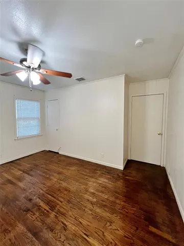 a view of an empty room with a chandelier fan