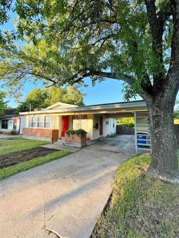a front view of a house with a garden and trees