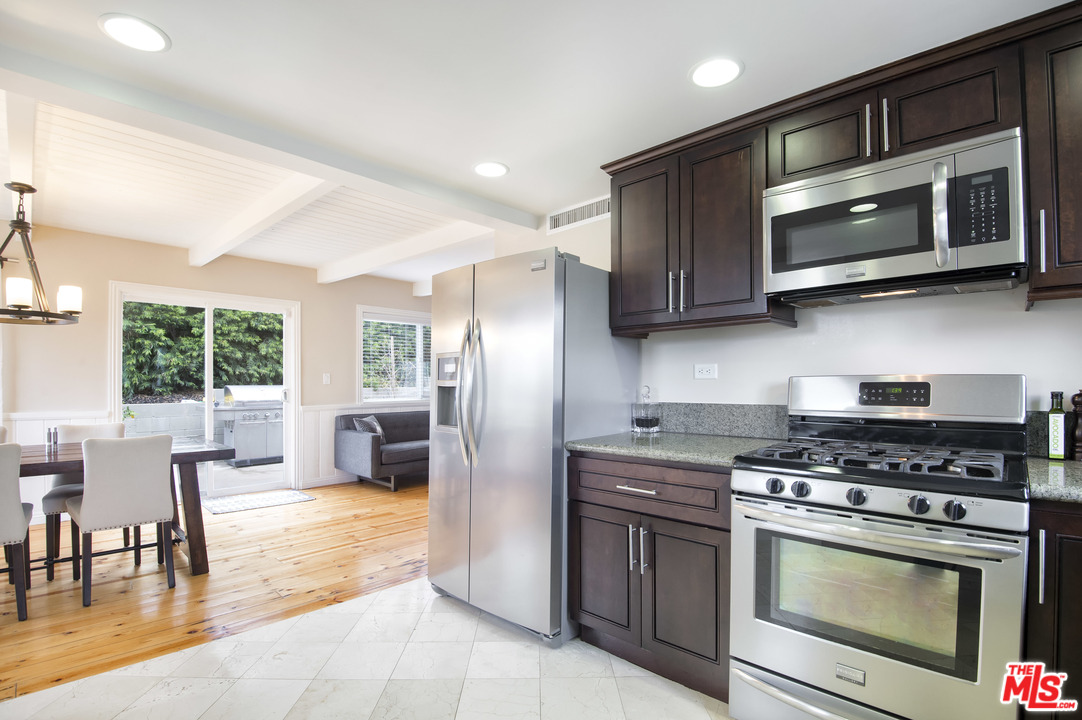 26258 Fairside Road Malibu, CA 90265 - Photo 11 of 46 a kitchen with stainless steel appliances wooden cabinets and a stove top oven