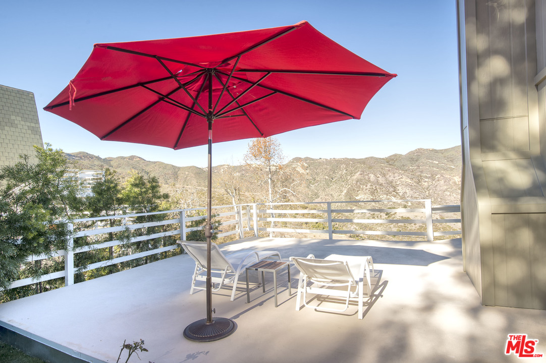 26258 Fairside Road Malibu, CA 90265 - Photo 36 of 46 a view of a balcony with chair and umbrella