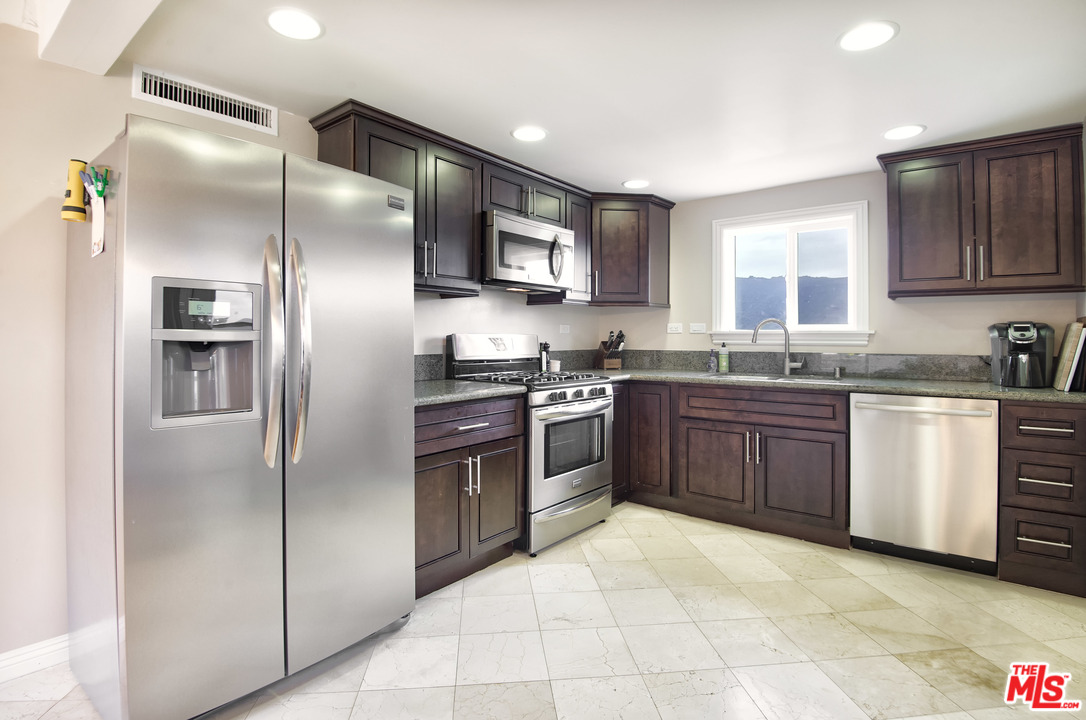 26258 Fairside Road Malibu, CA 90265 - Photo 10 of 46 a kitchen with stainless steel appliances granite countertop a refrigerator stove a sink and dishwasher