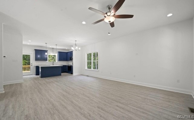 13985 Cross County Road Mineral, VA 23117 - Photo 4 of 27 an empty room with wooden floor a kitchen view and a ceiling fan
