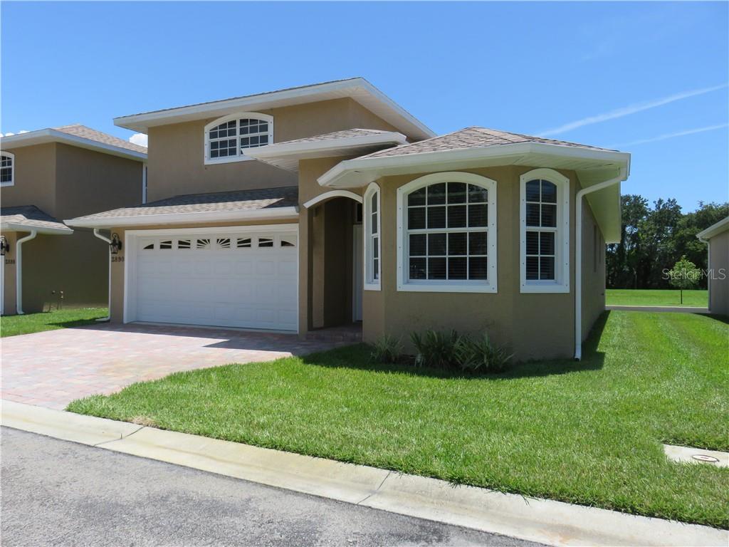 2890 Ashton Road Sarasota, FL 34231 - Photo 1 of 1 a front view of a house with a garden and yard