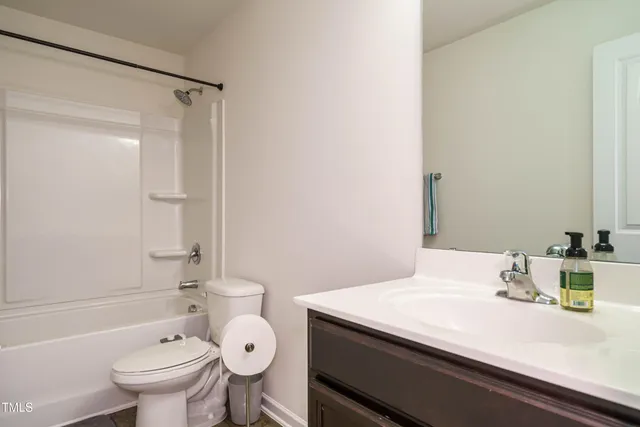 a bathroom with a sink a toilet and shower curtain