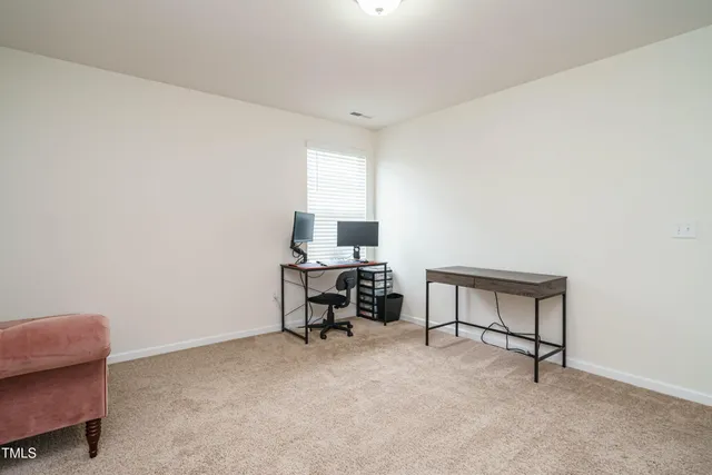 a view of a workspace with furniture and a window
