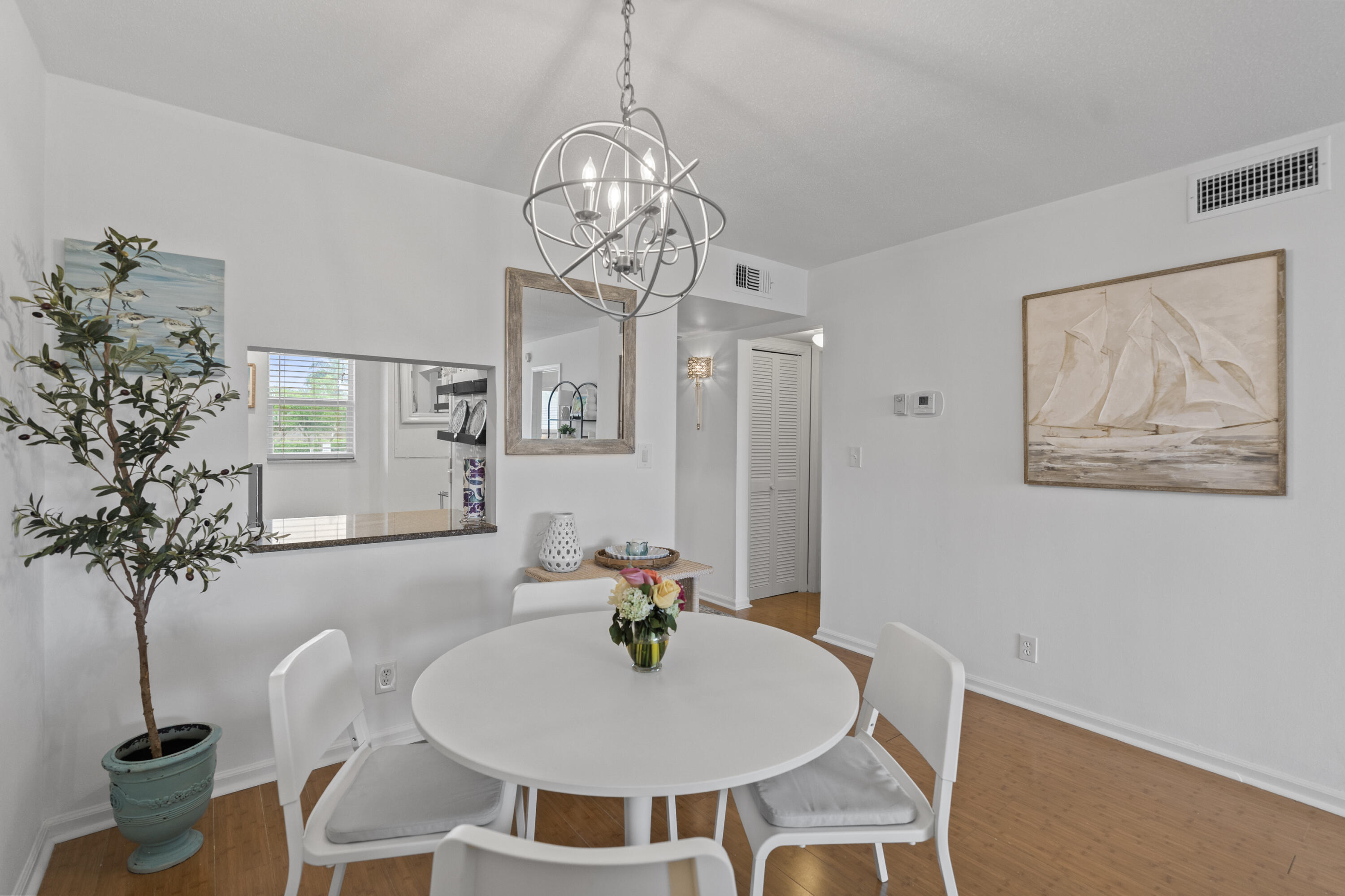 750 Northeast Spanish River Boulevard, Unit 2040 Boca Raton, FL 33431 - Photo 17 of 40 a view of a dining room with furniture wooden floor and chandelier