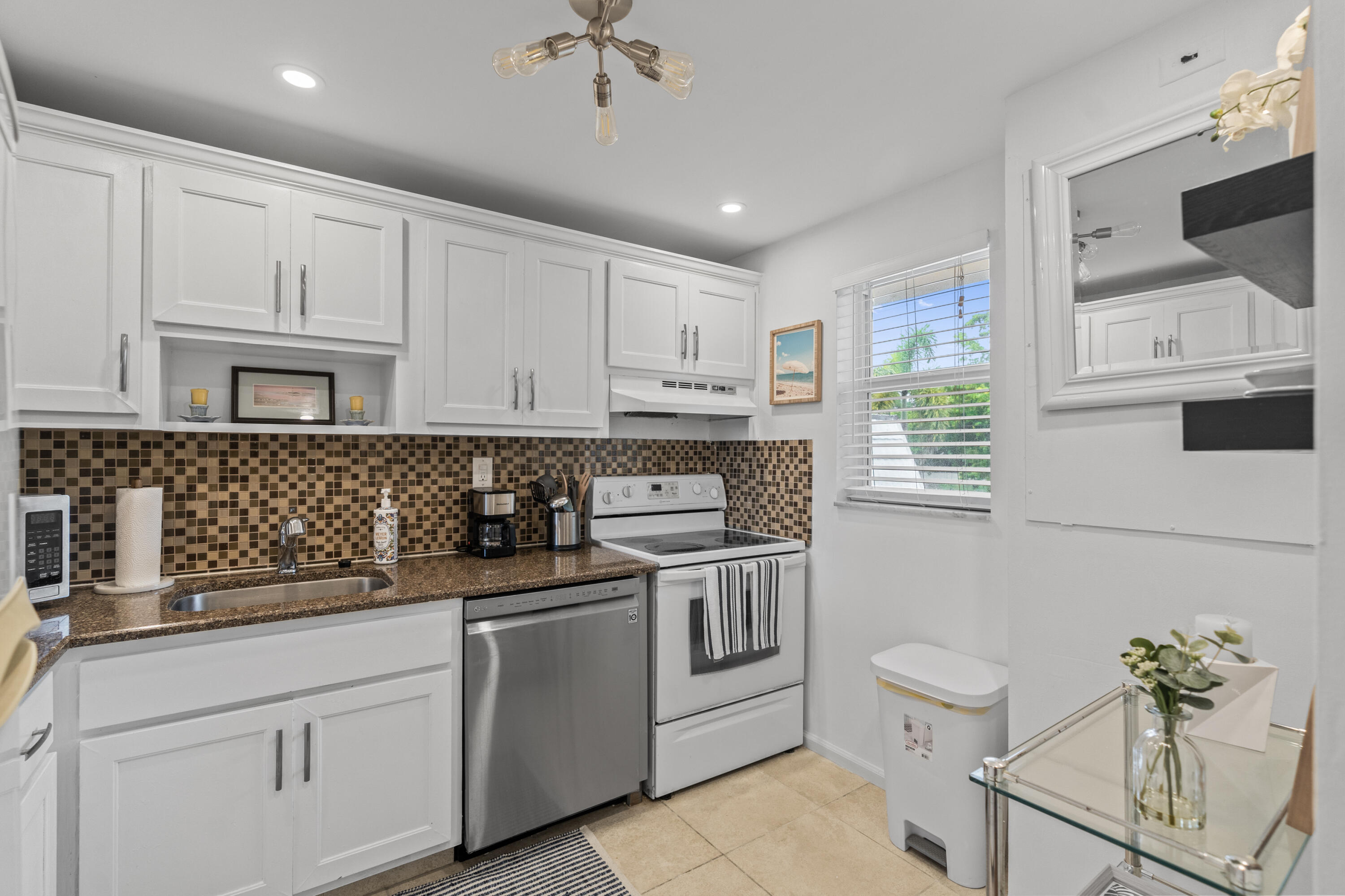 750 Northeast Spanish River Boulevard, Unit 2040 Boca Raton, FL 33431 - Photo 19 of 40 a kitchen with white cabinets and white appliances