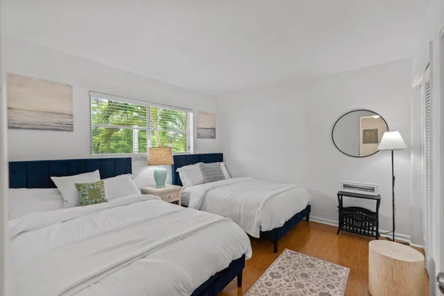 a bedroom with two beds and a large mirror