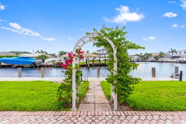 a view of swimming pool with lawn chairs and plants