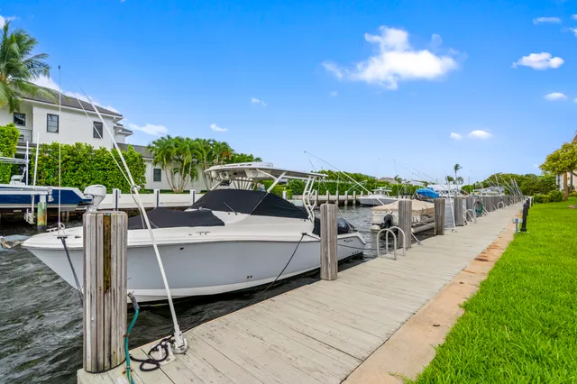 a view of a patio with a table and chairs under an umbrella with potted plants