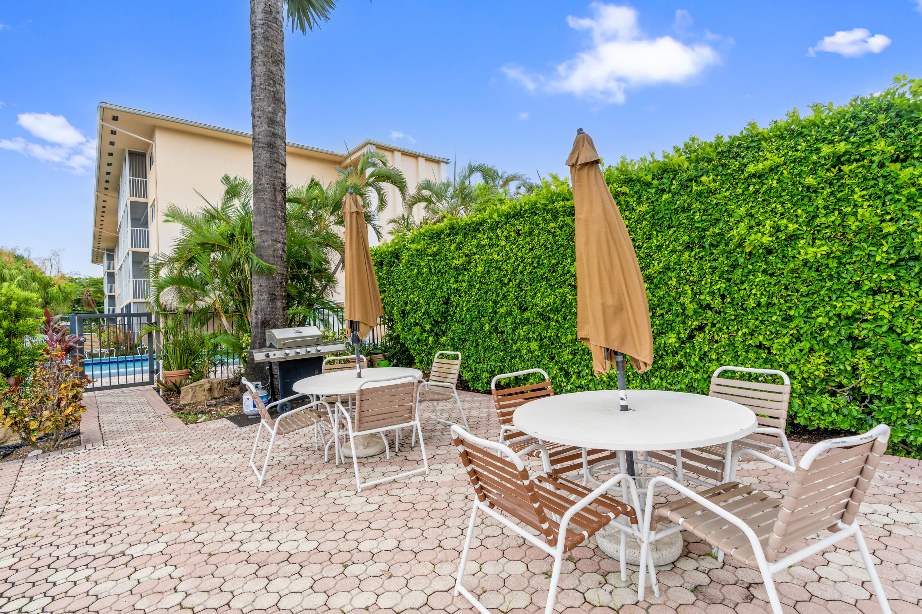 750 Northeast Spanish River Boulevard, Unit 2040 Boca Raton, FL 33431 - Photo 35 of 40 a view of a patio with a table and chairs under an umbrella with potted plants