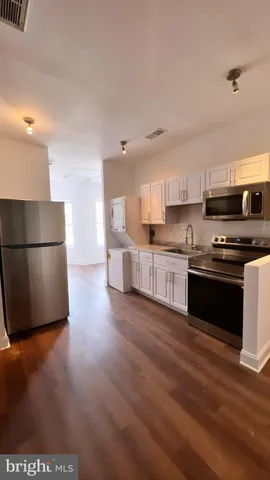 a kitchen with stainless steel appliances a refrigerator sink and microwave