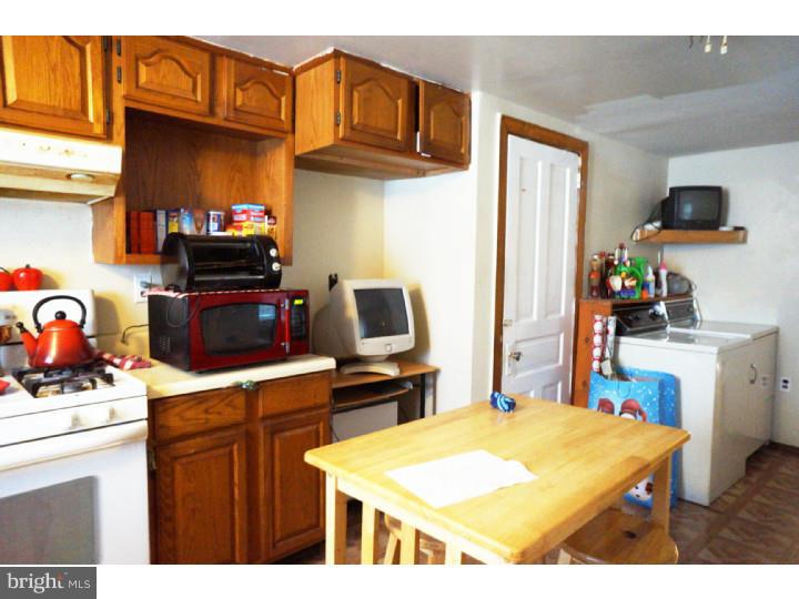 6016 West Thompson Street Philadelphia, PA 19151 - Photo 6 of 17 a kitchen with stainless steel appliances kitchen island granite countertop a sink stove and refrigerator