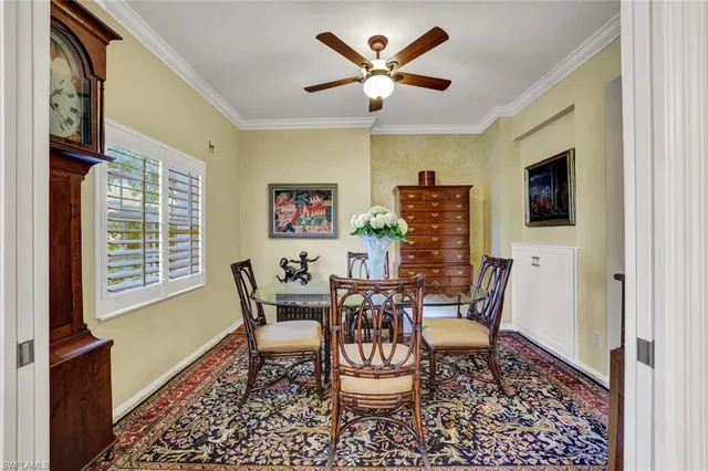 a dining room with furniture a rug and a floor to ceiling window