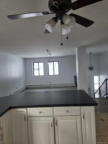 a kitchen with stainless steel appliances granite countertop a refrigerator a stove a sink dishwasher a refrigerator and white cabinets with wooden floor