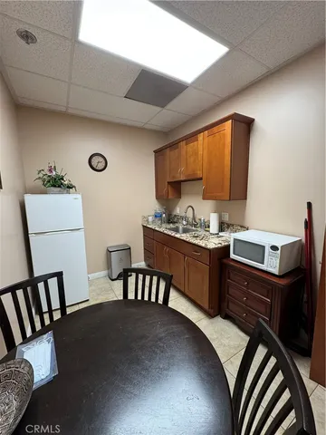 a kitchen with a table chairs and a refrigerator
