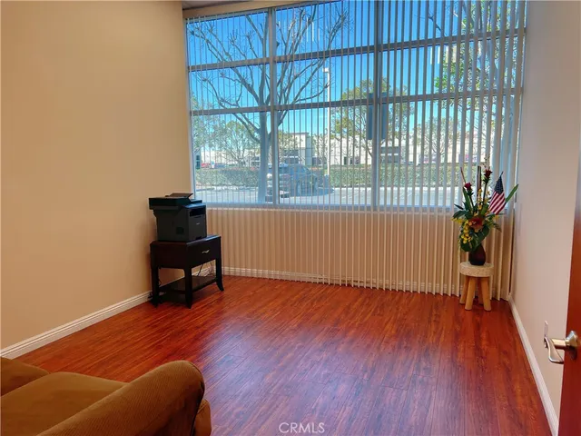 an empty room with windows and wooden floor