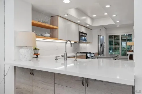 a kitchen with stainless steel appliances a stove microwave and sink