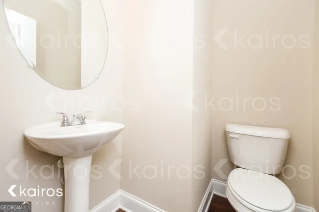a bathroom with a toilet sink and mirror