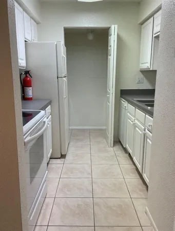 a kitchen with a refrigerator and a stove top oven