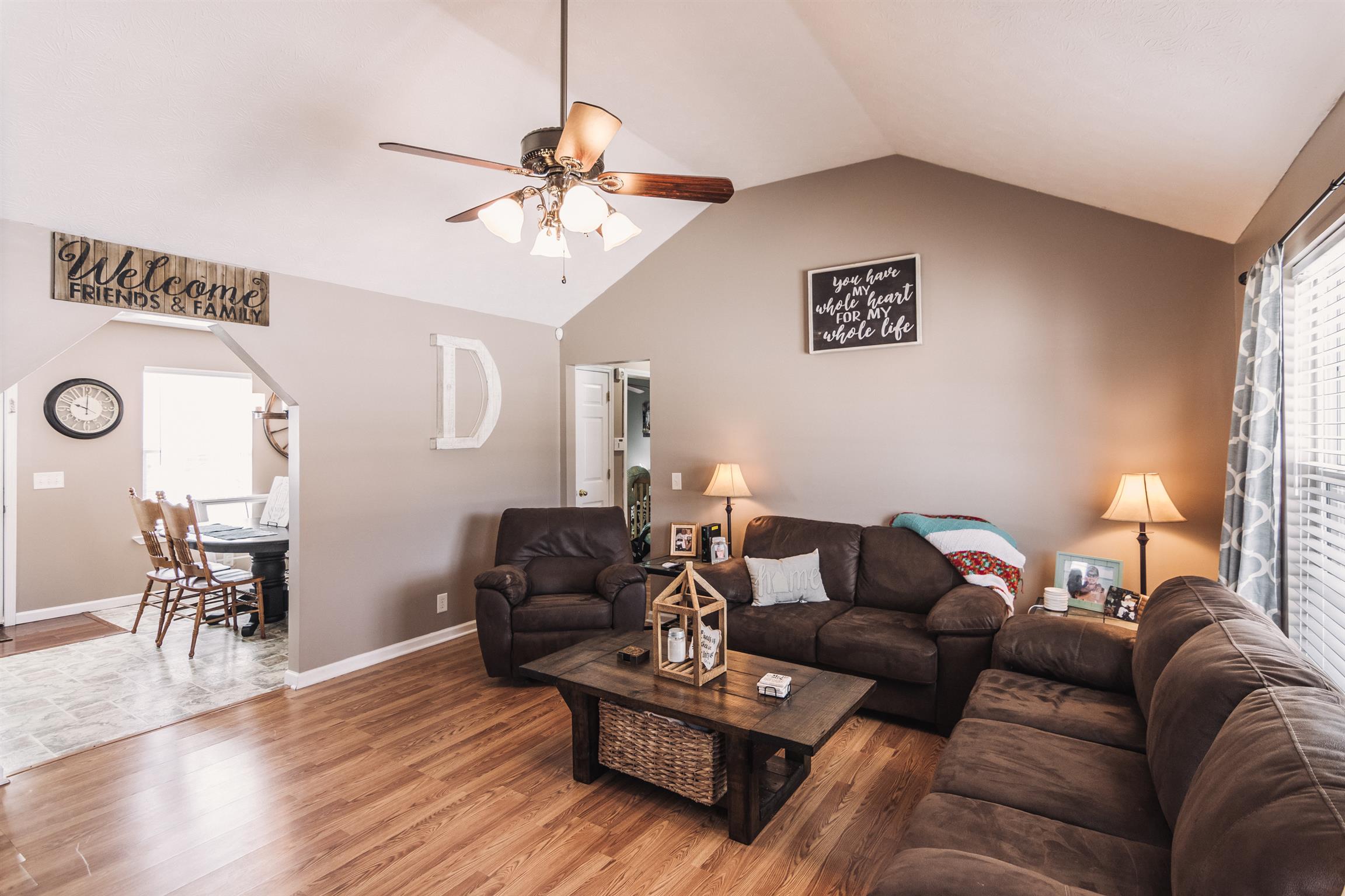399 Corinth Road Portland, TN 37148 - Photo 2 of 28 a living room with furniture a wooden floor and a chandelier