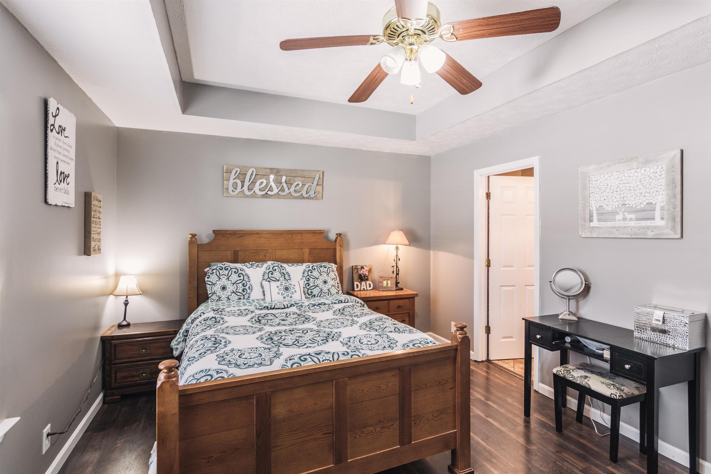 399 Corinth Road Portland, TN 37148 - Photo 14 of 28 a bedroom with a bed and a chandelier