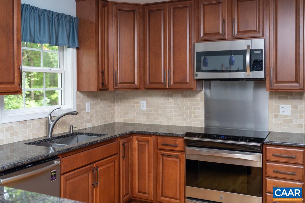 164 Wind Ridge Drive Ruckersville, VA 22968 - Photo 40 of 51 a kitchen with granite countertop wooden cabinets and a stove top oven