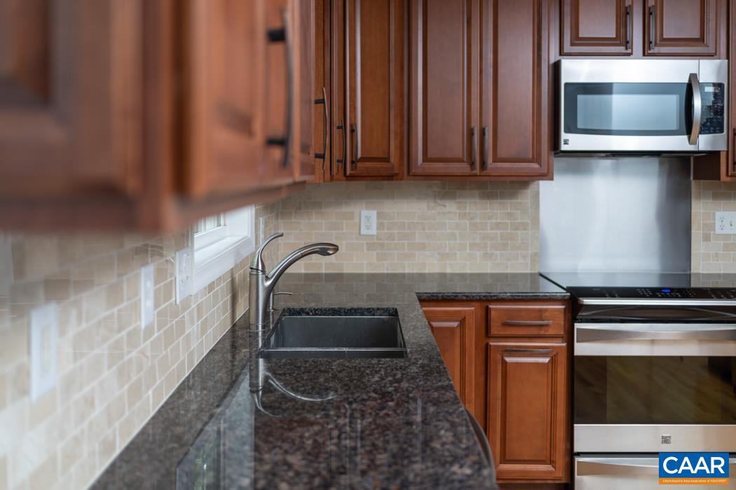 164 Wind Ridge Drive Ruckersville, VA 22968 - Photo 41 of 51 a kitchen with granite countertop a sink and a microwave