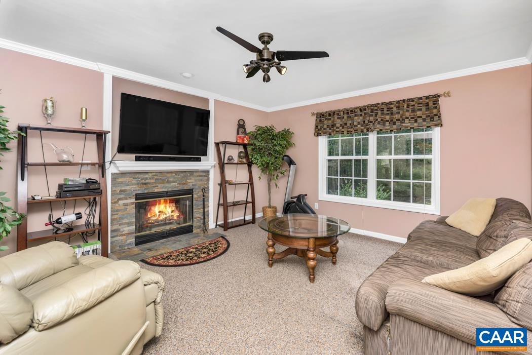 164 Wind Ridge Drive Ruckersville, VA 22968 - Photo 5 of 51 a living room with furniture a fireplace and a flat screen tv