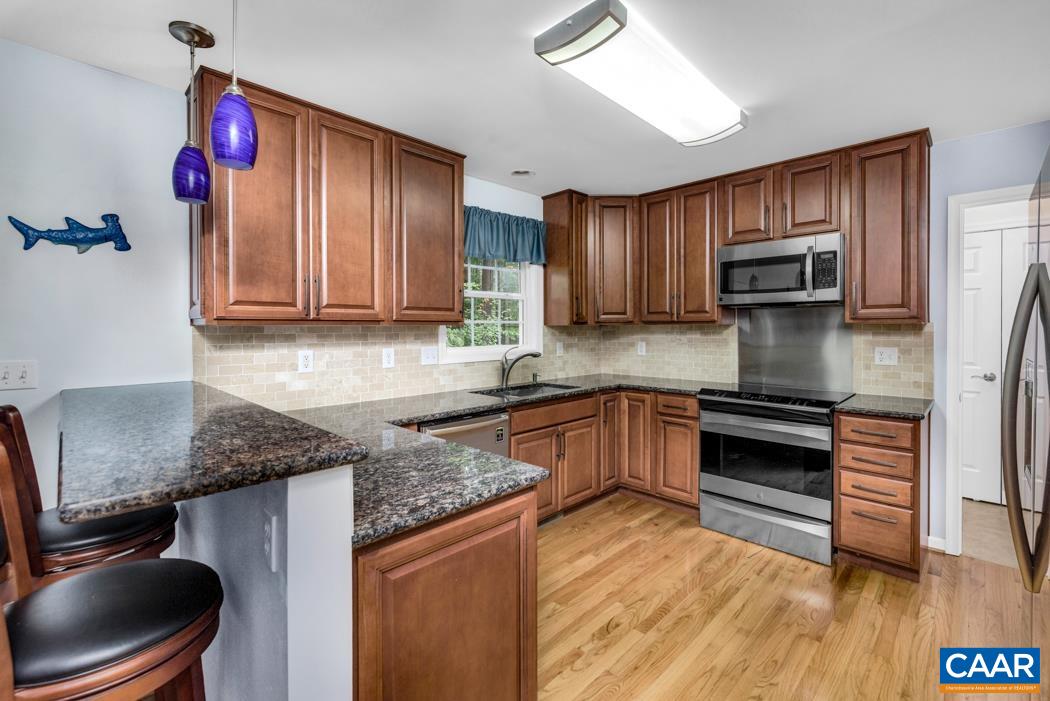 164 Wind Ridge Drive Ruckersville, VA 22968 - Photo 8 of 51 a kitchen with granite countertop kitchen island stainless steel appliances a stove refrigerator sink and cabinets