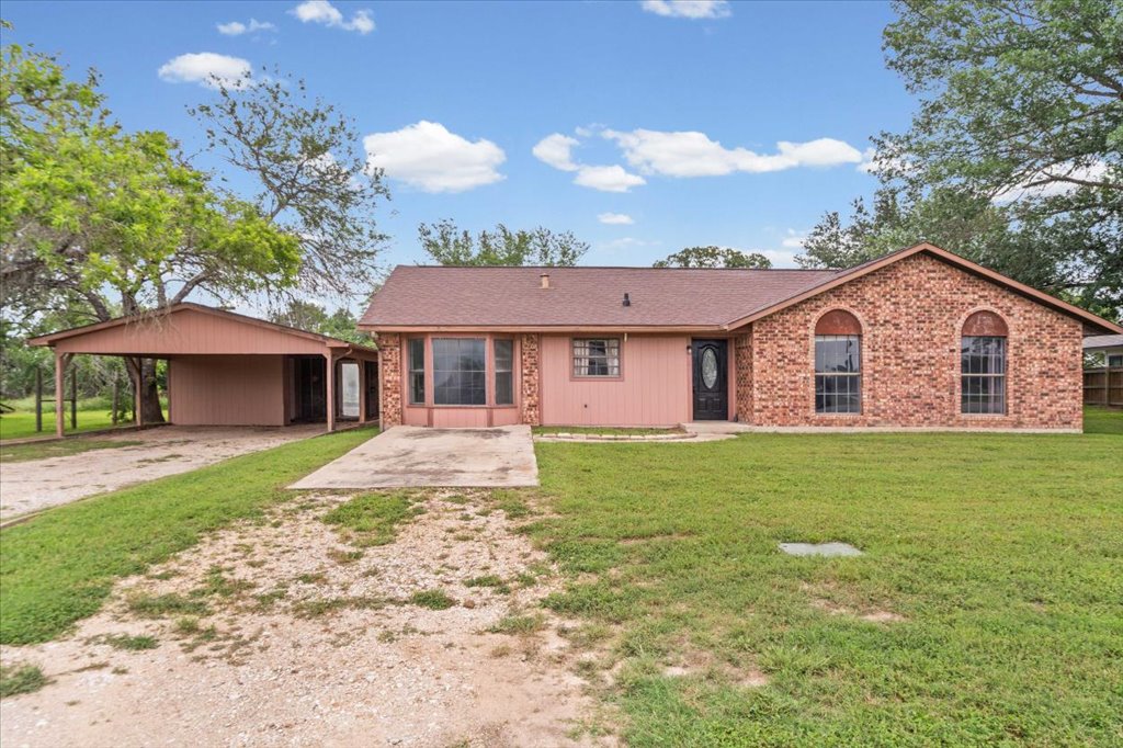 650 West Austin Street Luling, TX 78648 - Photo 2 of 18 A classic ranch home features a covered carport, expansive front yard, and charming brick accents.