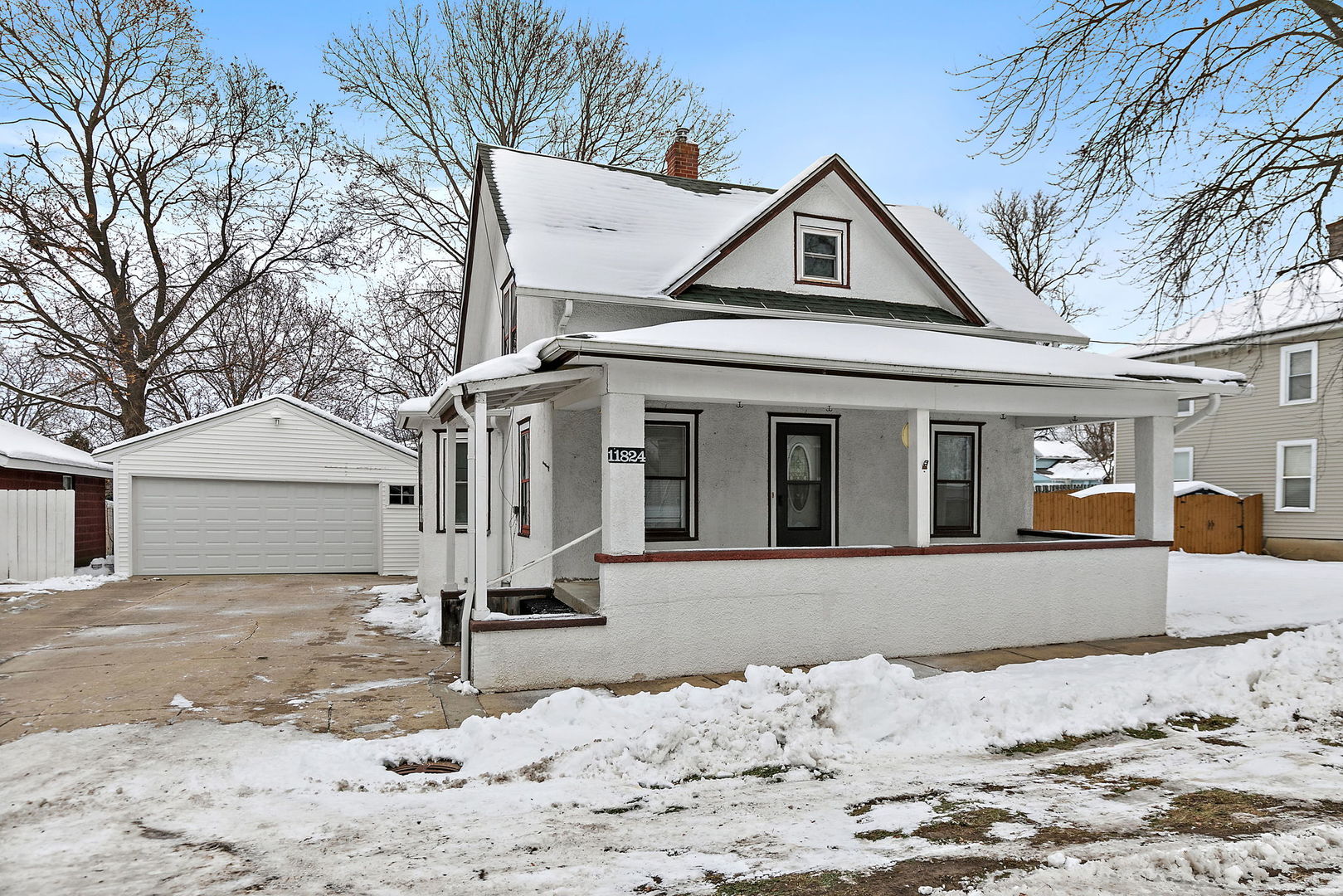 a front view of a house with a yard covered in snow