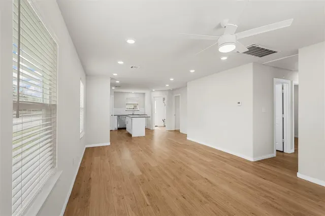 a view of a kitchen with wooden floor and a window