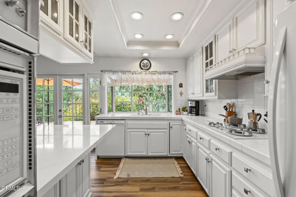 3907 United Road Agoura Hills, CA 91301 - Photo 11 of 34 a kitchen with white cabinets and wooden floors