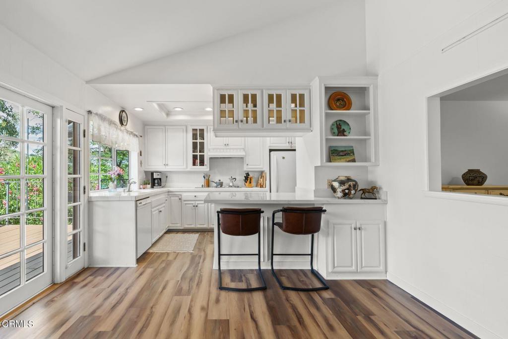 3907 United Road Agoura Hills, CA 91301 - Photo 9 of 34 a kitchen with a sink dishwasher a dining table and chairs with wooden floor