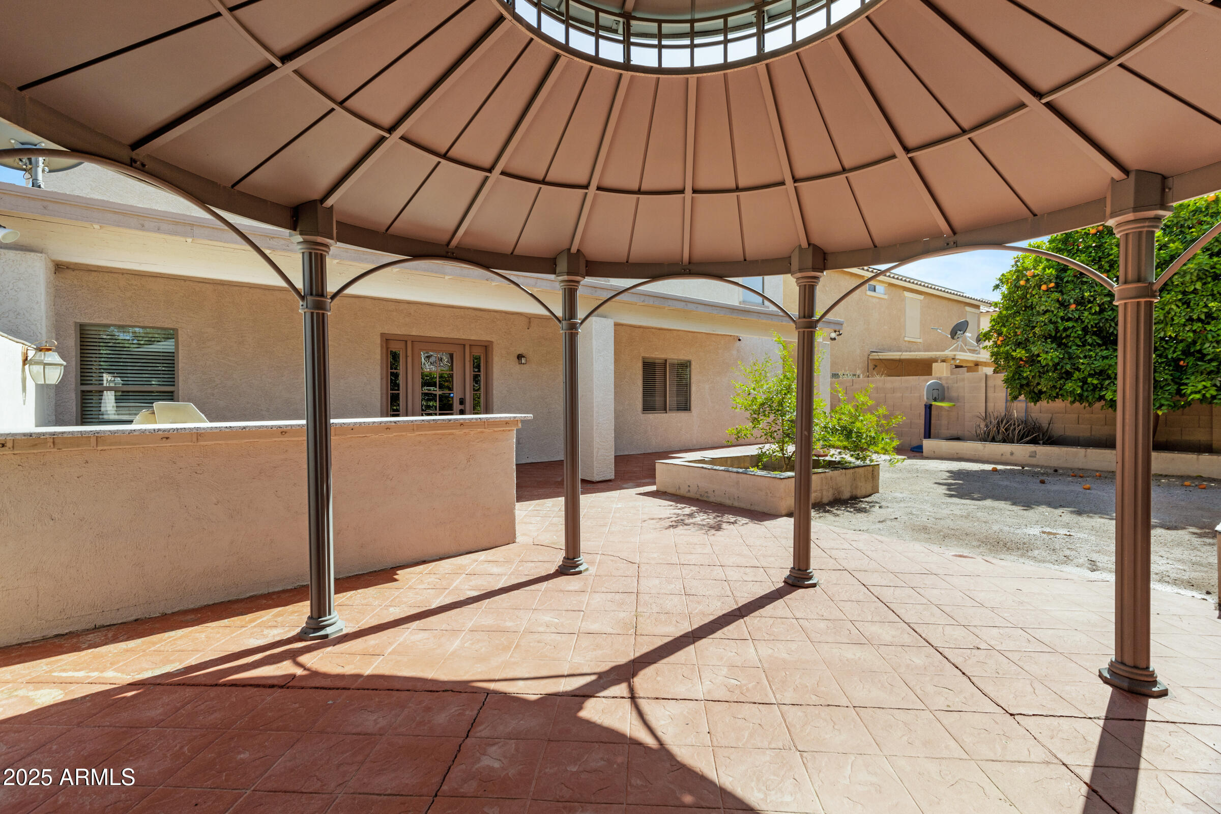 43232 West Magnolia Road Maricopa, AZ 85138 - Photo 54 of 58 a patio with a table and chairs under an umbrella