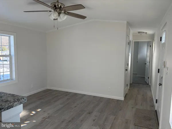 a view of empty room with a window and a ceiling fan