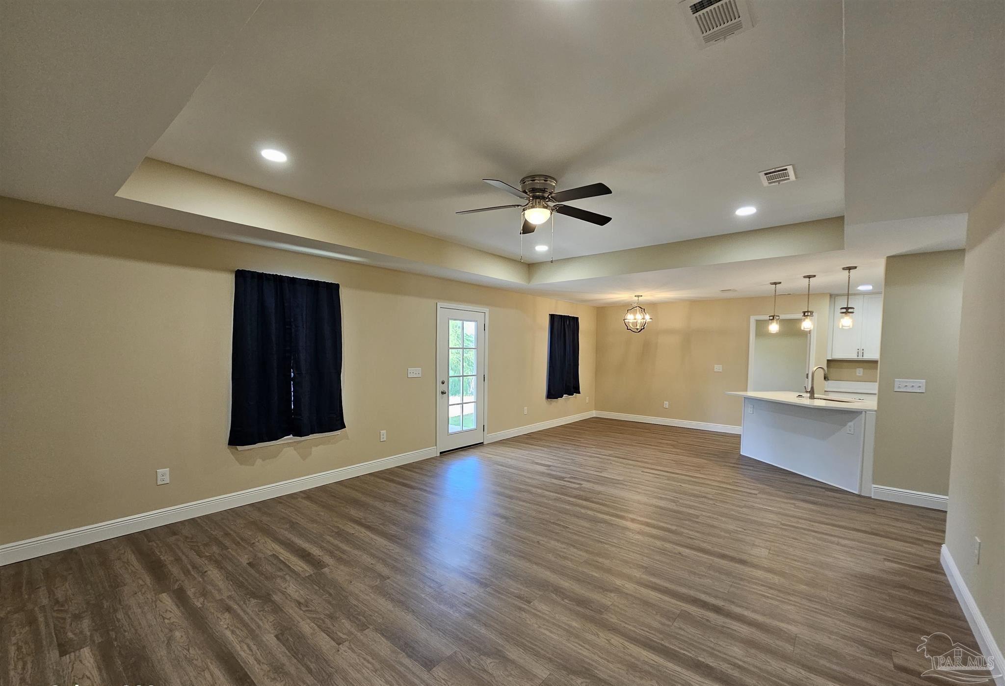 295 West Kingsfield Road Cantonment, FL 32533 - Photo 11 of 32 a view of an empty room with wooden floor and a ceiling fan