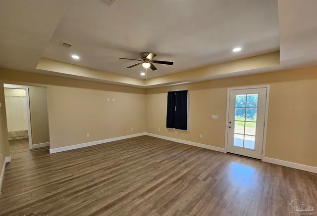 an empty room with closet and a ceiling fan