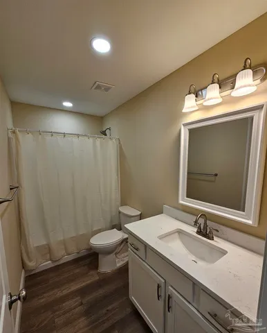 a view of a hallway with a ceiling fan and wooden floor