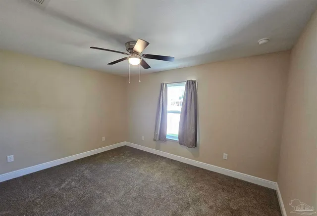 an empty room with closet and a chandelier fan