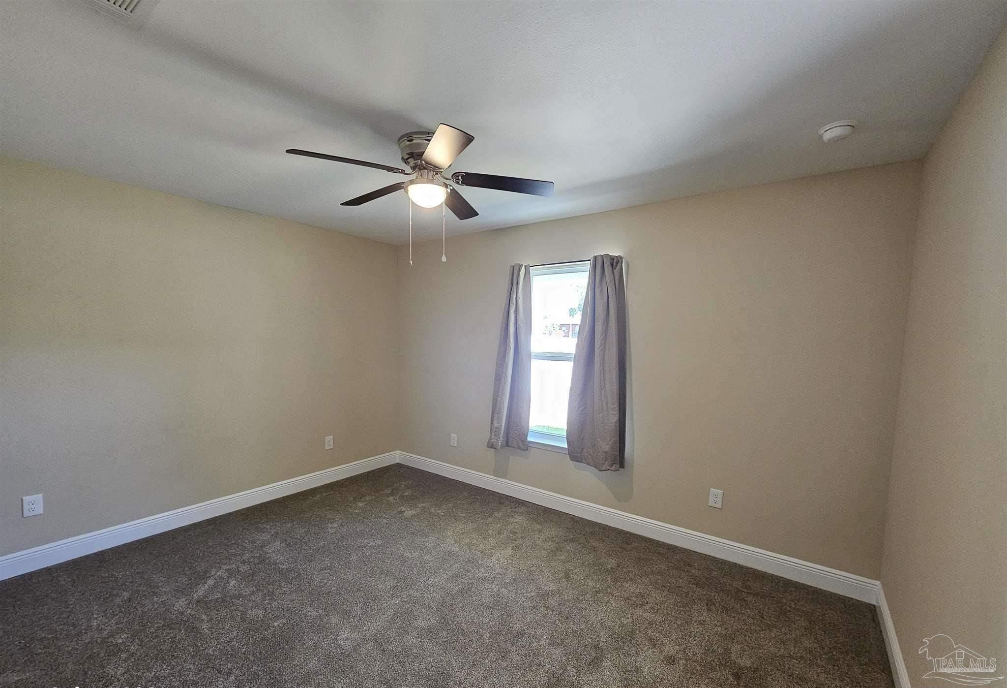 295 West Kingsfield Road Cantonment, FL 32533 - Photo 18 of 32 an empty room with chandelier fan and windows