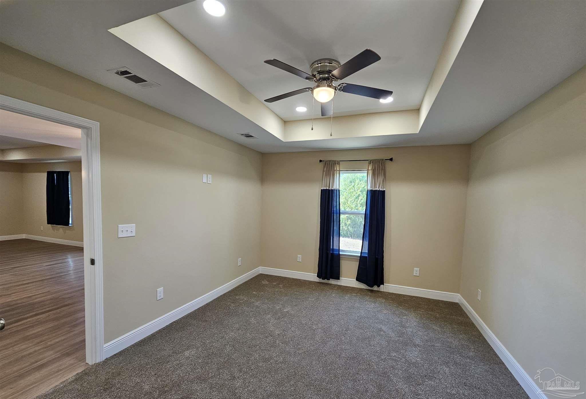 295 West Kingsfield Road Cantonment, FL 32533 - Photo 21 of 32 a view of an empty room with wooden floor and a ceiling fan