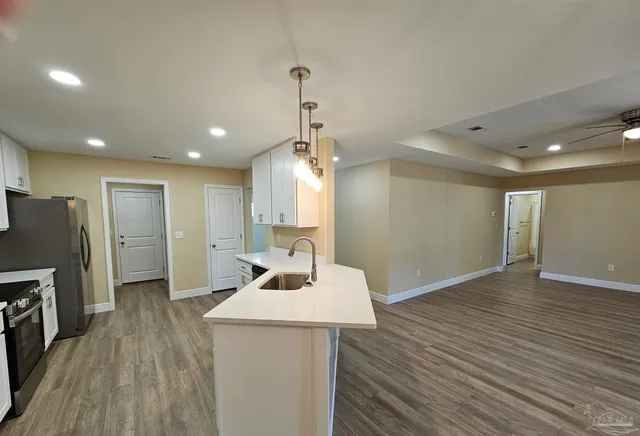 a kitchen with stainless steel appliances a refrigerator sink and microwave