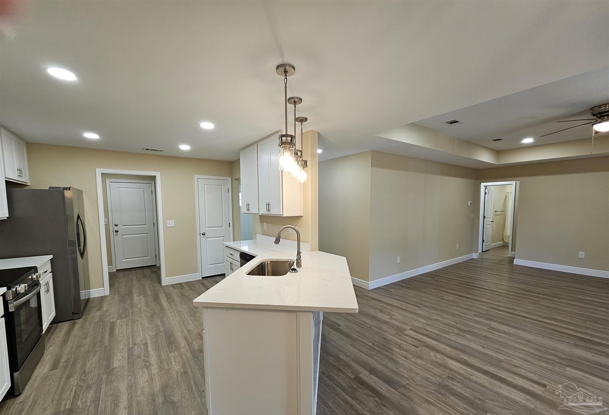 295 West Kingsfield Road Cantonment, FL 32533 - Photo 6 of 32 a view of a kitchen cabinets a sink wooden floor and a living room