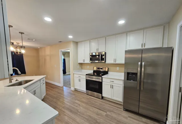 a large kitchen with kitchen island a sink stainless steel appliances and cabinets