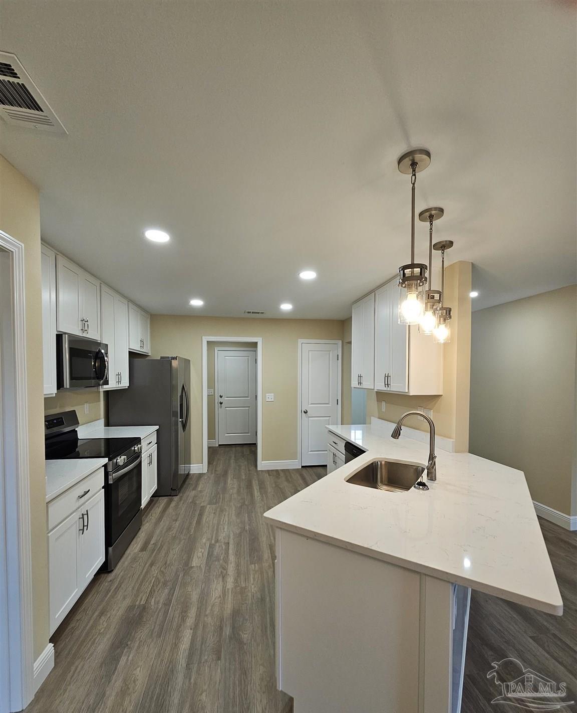 295 West Kingsfield Road Cantonment, FL 32533 - Photo 8 of 32 a large kitchen with kitchen island a sink stainless steel appliances and cabinets