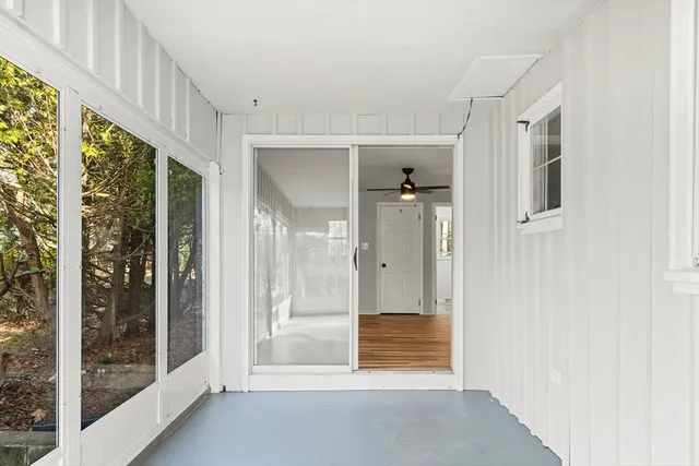 a view of a hallway with wooden floor and windows